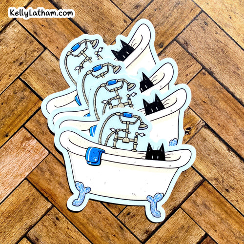 A stack of three die-cut stickers featuring a cartoon bathtub scene with black cats, shown on a wooden parquet floor. The top-left corner features the brand watermark 'KellyLatham.
