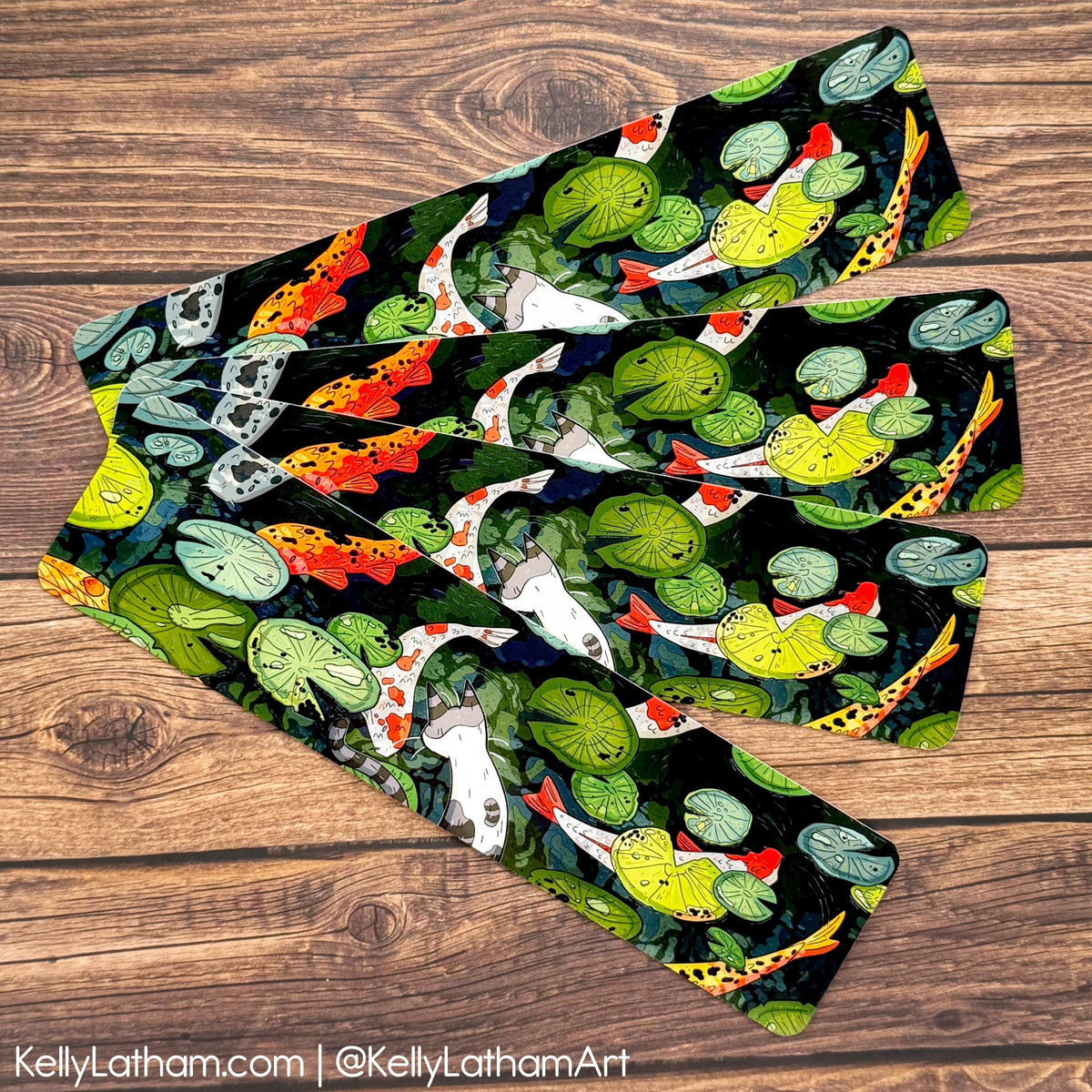 A pair of leggings with a detailed koi fish and lotus pond pattern, laid flat on a rustic wooden background.