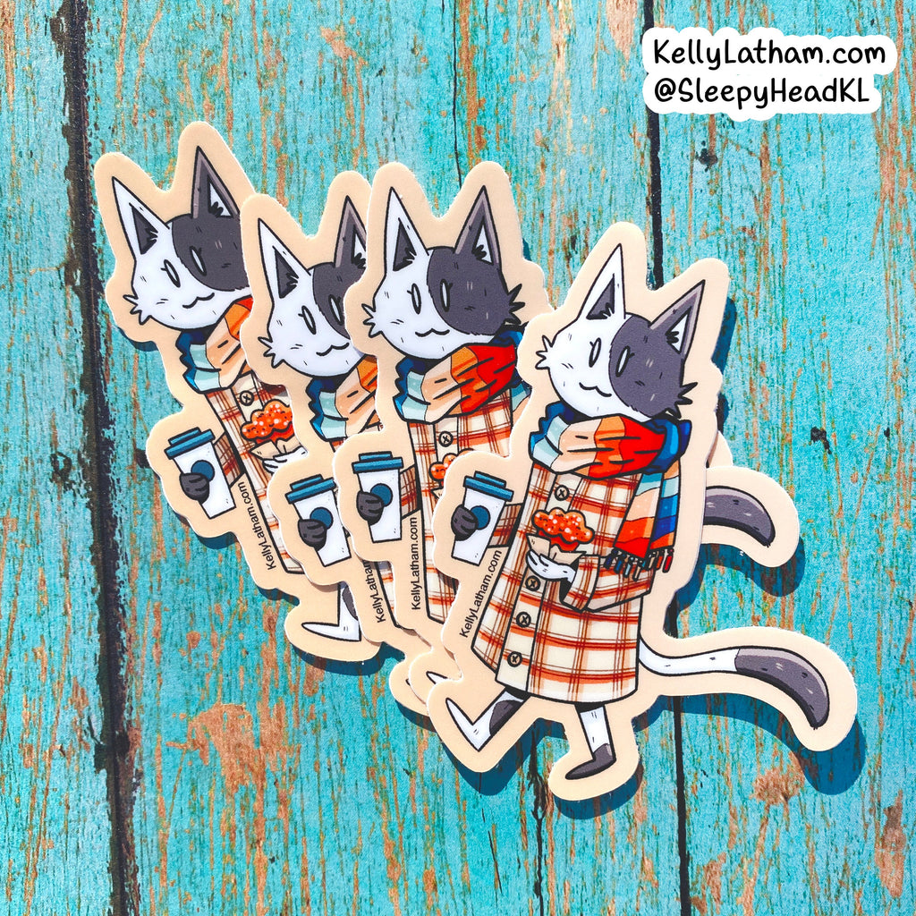 Four die-cut stickers featuring an illustrated black-and-white cat in a red-and-white plaid coat and blue scarf, each holding a coffee cup, arranged on a distressed turquoise wooden background. A watermark in the top right reads KellyLatham.