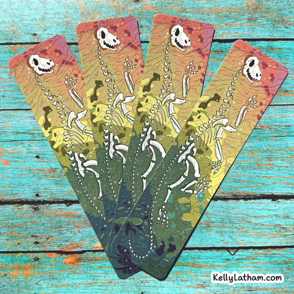 Five tarot cards with dinosaur skeletons on a wooden surface, featuring the artist's name 'kellylatham.com'.