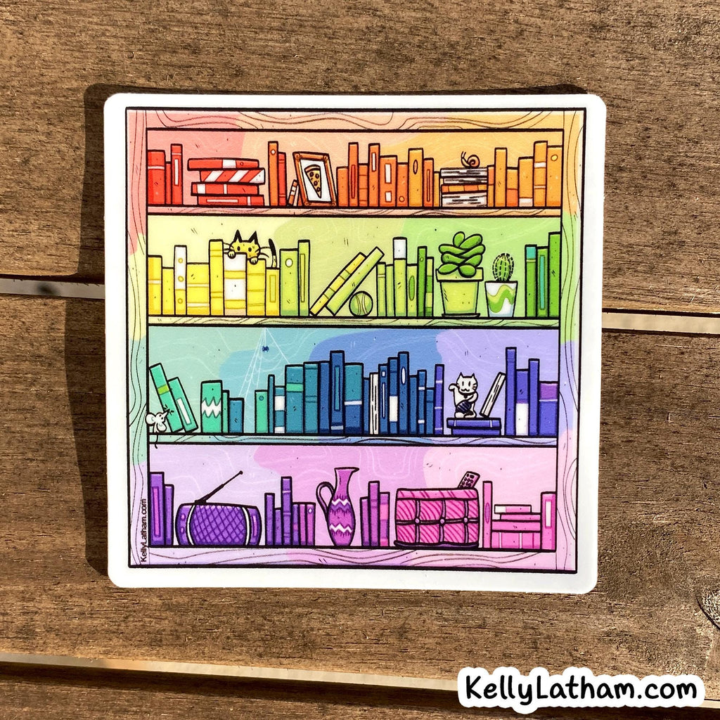 A square sticker featuring a colorful illustration of three bookshelves filled with books, plants, and small cat silhouettes, placed on a wooden surface. The sticker has a white border and the text 'KellyLatham.