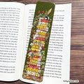 A green book divider with a colorful illustration of a librarian holding a stack of books, placed on an open book.