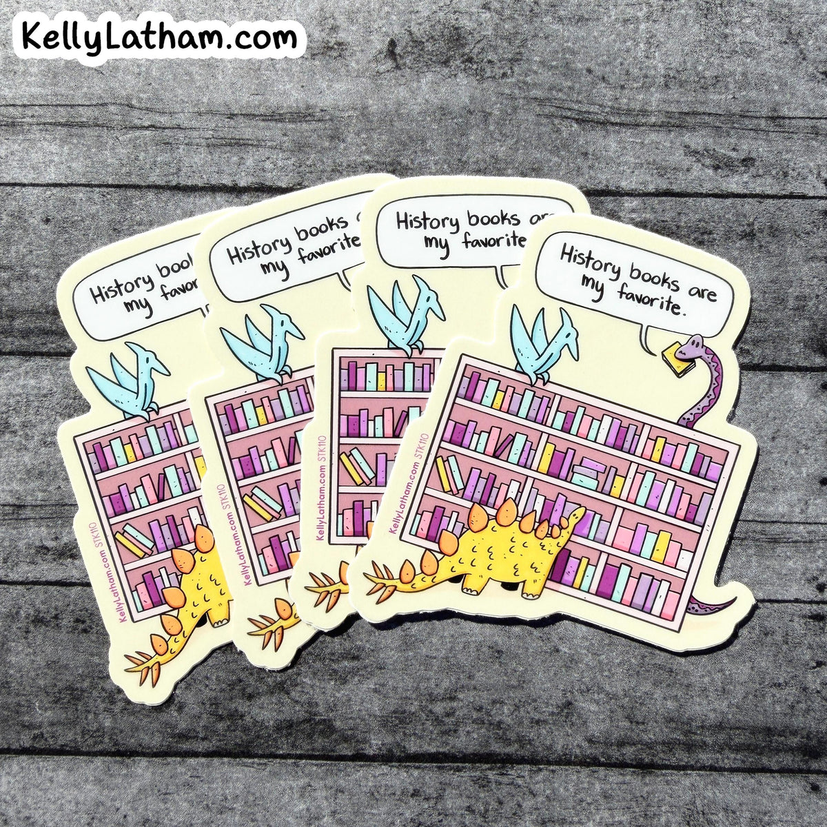 Four cartoon dinosaur bookshelf stickers arranged in a fan shape on a gray wood plank background. The stickers feature colorful bookshelves filled with books, blue birds, and dinosaurs, with speech bubbles reading 'History books are my favorite.