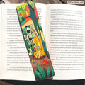 An open book spread with printed text on both pages and a colorful illustration of a skateboarder in a red, yellow, and green outfit riding a skateboard near the center. The name KellyLatham.