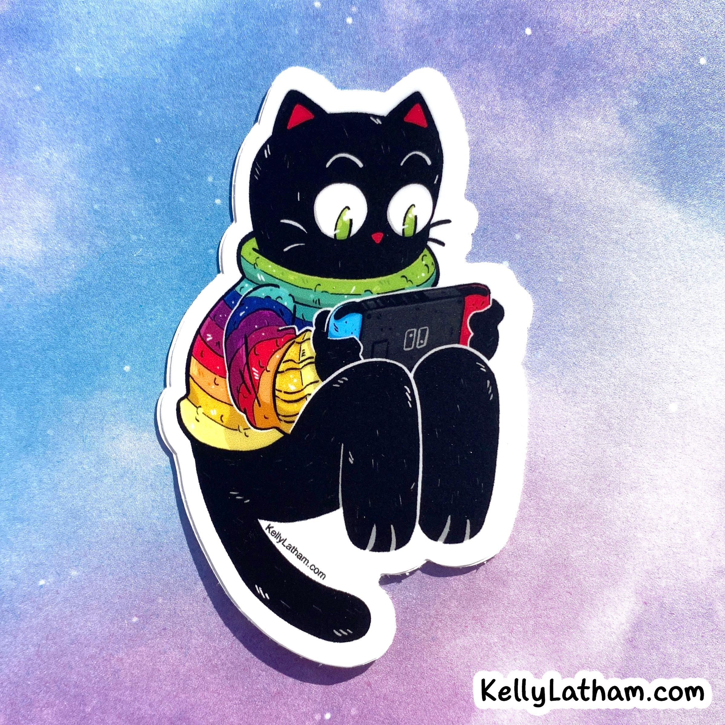 A die-cut sticker featuring a cartoon black cat wearing a bright rainbow jacket and green scarf, holding a tablet. The sticker is displayed against a pastel purple and blue galaxy background with the text 'KellyLatham.