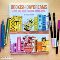 Bookish Daydreams: Cute and Relaxing Coloring Book by Kelly Latham, displayed on a light wood background with colored pencils on the left and markers on the right.