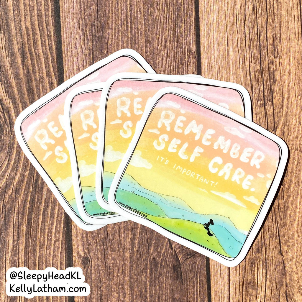 Three square stickers with rounded corners fanned out on a brown wood background. The stickers feature a watercolor-style illustration of a person hiking on a mountain with the text 'REMEMBER SELF CARE.