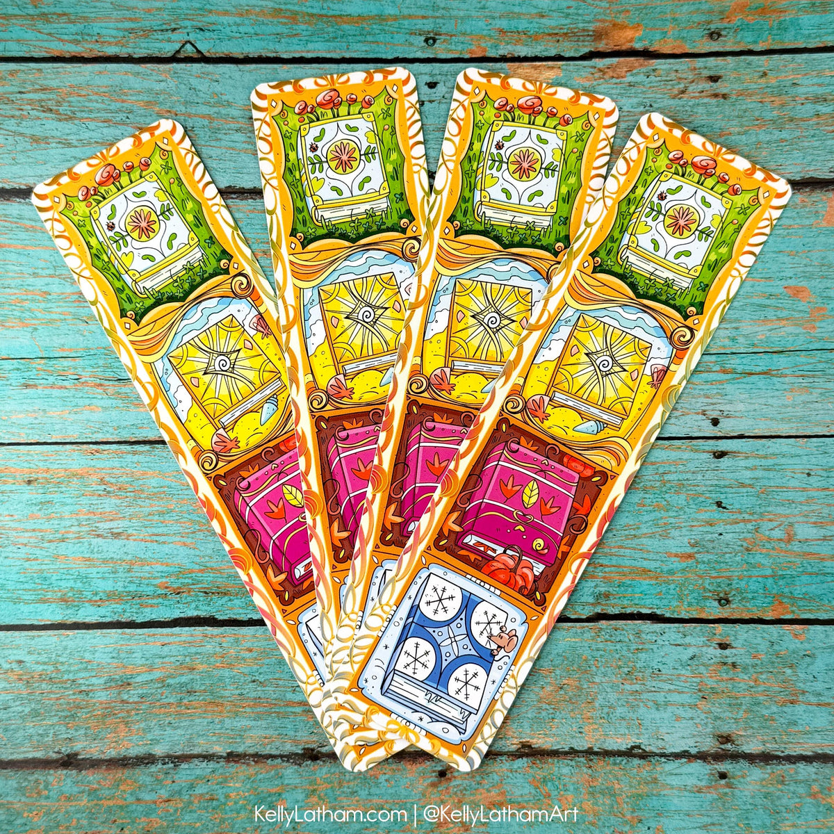 Five illustrated tarot-style cards fanned out on a distressed turquoise wooden surface. The cards feature ornate vintage borders and colorful imagery including a green shield, yellow sunburst, pink vehicle, and blue clock.
