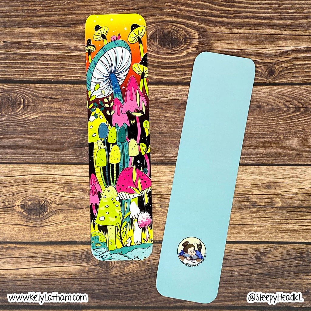 Two yoga mats displayed on a rustic wooden background. The mat on the left features a vibrant, multicolored psychedelic mushroom forest illustration, while the mat on the right is a solid light blue with a small circular cartoon logo near the bottom.