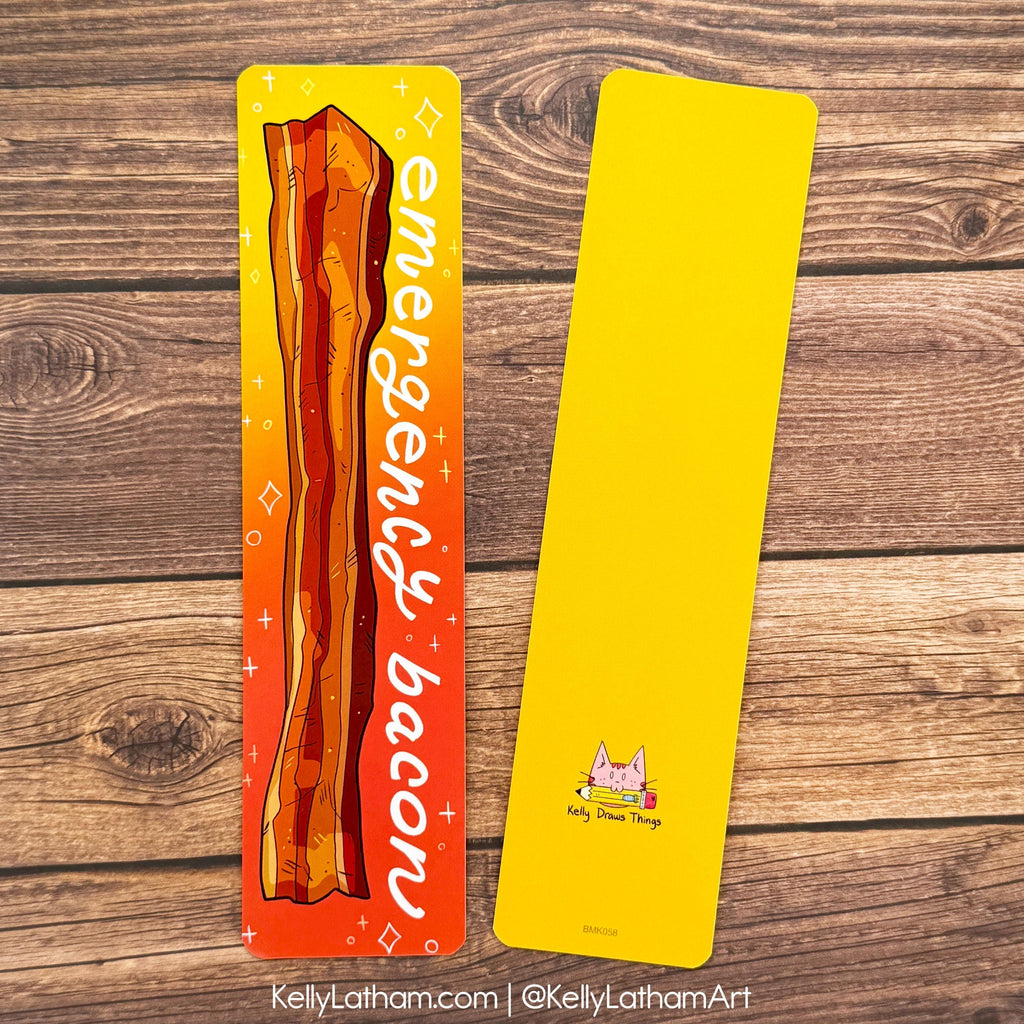 Two rectangular bookmarks laid flat on a rustic wood background. The left bookmark is orange-to-yellow gradient with an illustrated bacon strip and the words 'emergency bacon' in white script.