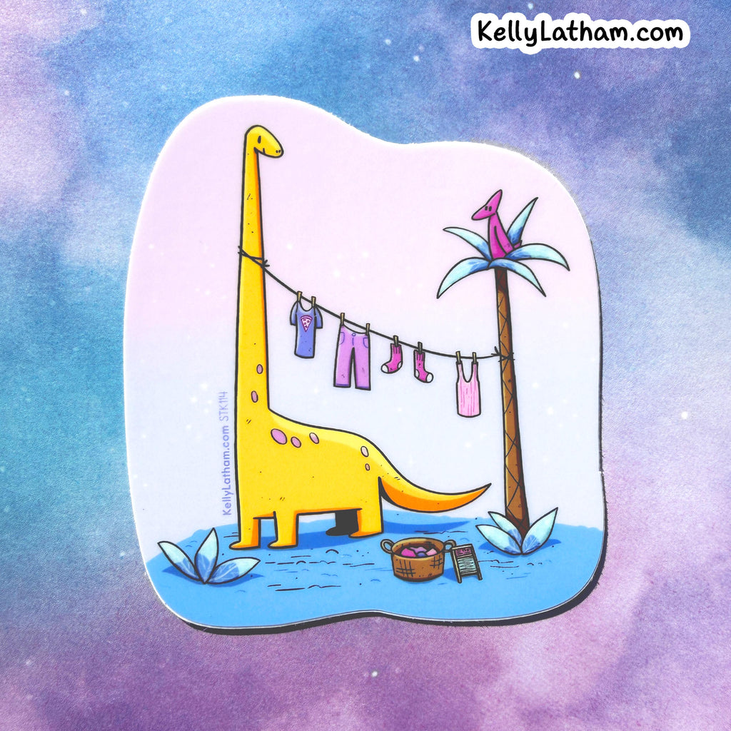 A die-cut sticker featuring a whimsical cartoon illustration of a yellow dinosaur drying laundry on a clothesline next to a palm tree, shown against a pastel purple and blue watercolor background. The brand name KellyLatham.
