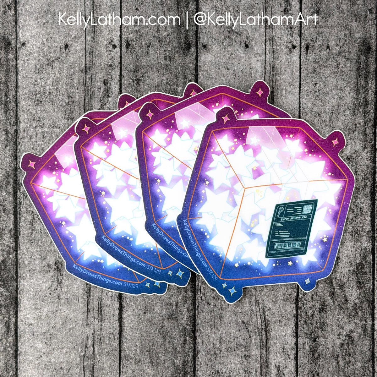 Three overlapping hexagonal art cards or stickers with a glowing star design in purple, pink, and blue, arranged on a gray wood plank background. A small dark rectangular panel is visible on the front card.