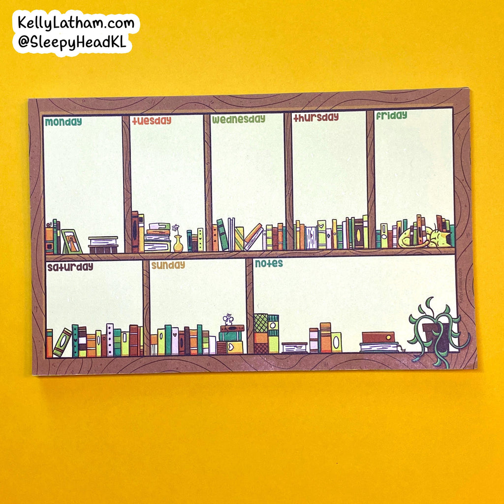A weekly planner notepad with a wood-grain border and six illustrated sections for Monday through Sunday, plus a notes column. The notepad is photographed flat against a bright yellow background.