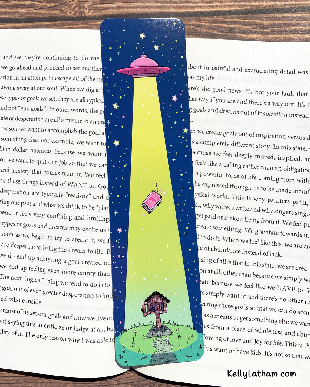 A close-up of a blue notebook or journal page featuring a colorful dreamcatcher illustration, positioned between two open books with printed text.