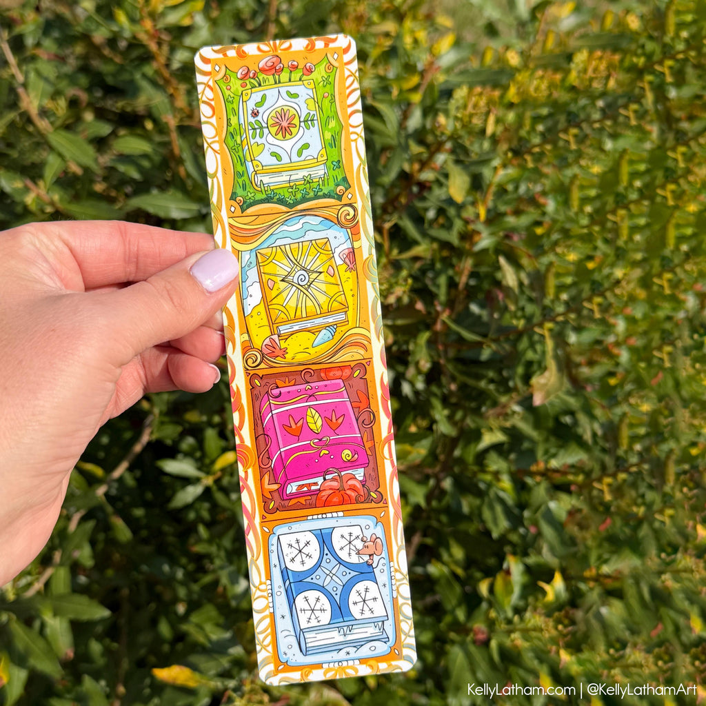 A hand holds a long, narrow illustrated card or bookmark outdoors in front of green foliage. The item has a white border with four colorful cartoon panels showing a flower, a sun, a pink car, and a blue clock, plus decorative orange and yellow patterns along the edges.