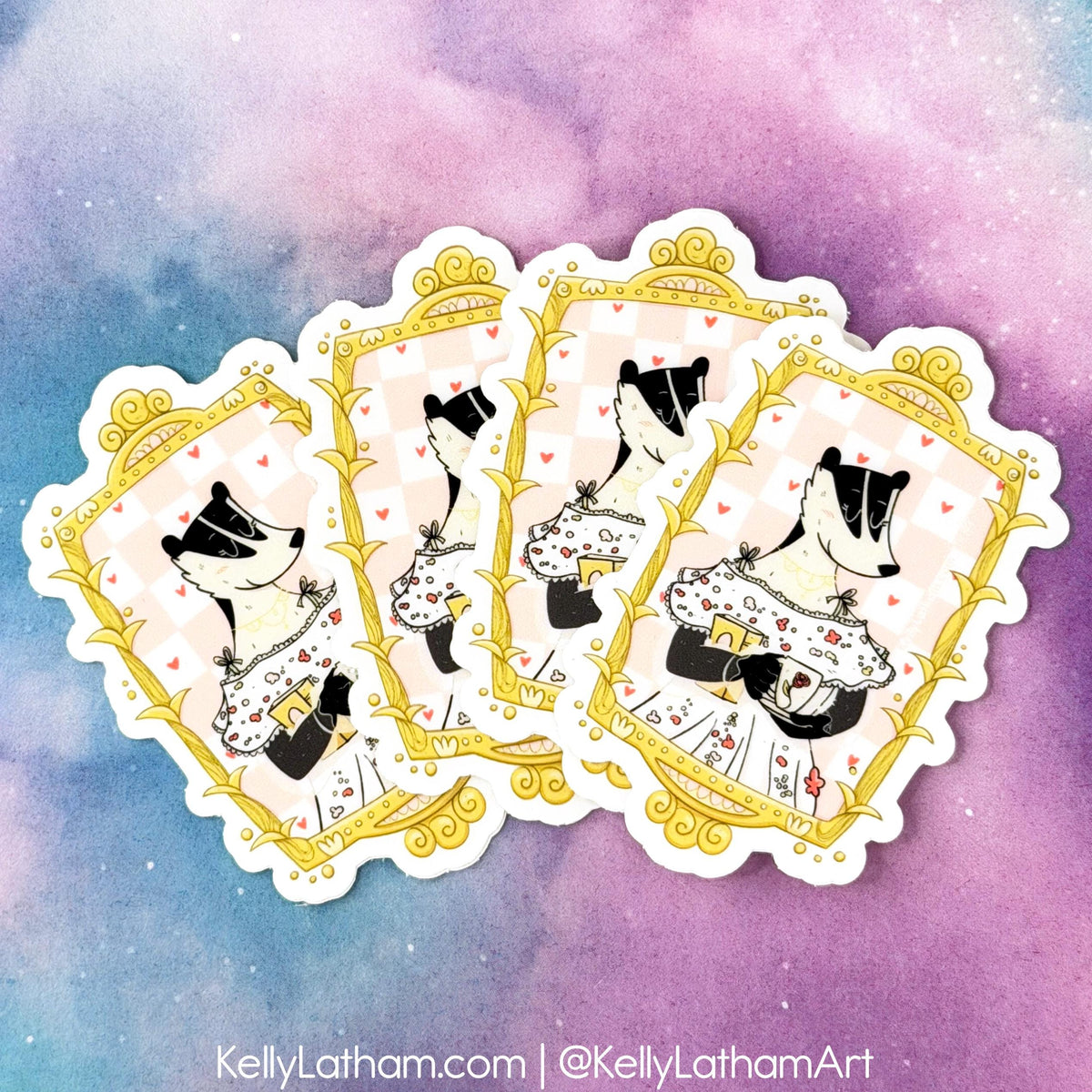 Three die-cut stickers featuring illustrated badgers in vintage card suits framed by ornate gold borders, arranged in a fan shape against a pastel purple and blue watercolor background.