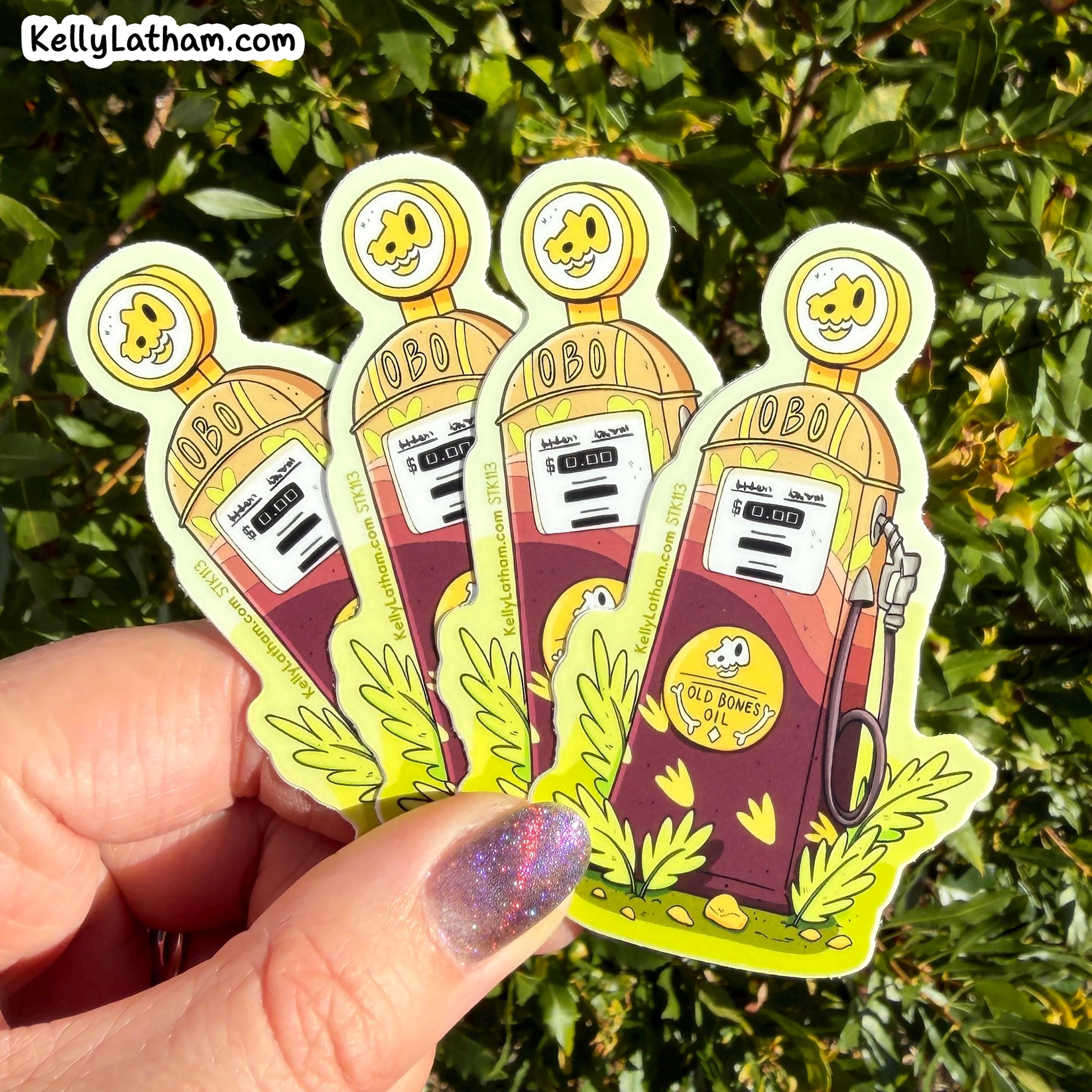 Four cartoon die-cut stickers of retro gas pumps held in a hand against a background of green foliage. The stickers feature a yellow cartoon character head, the text 'OBO!', a gas gauge, and green leafy accents at the bottom.