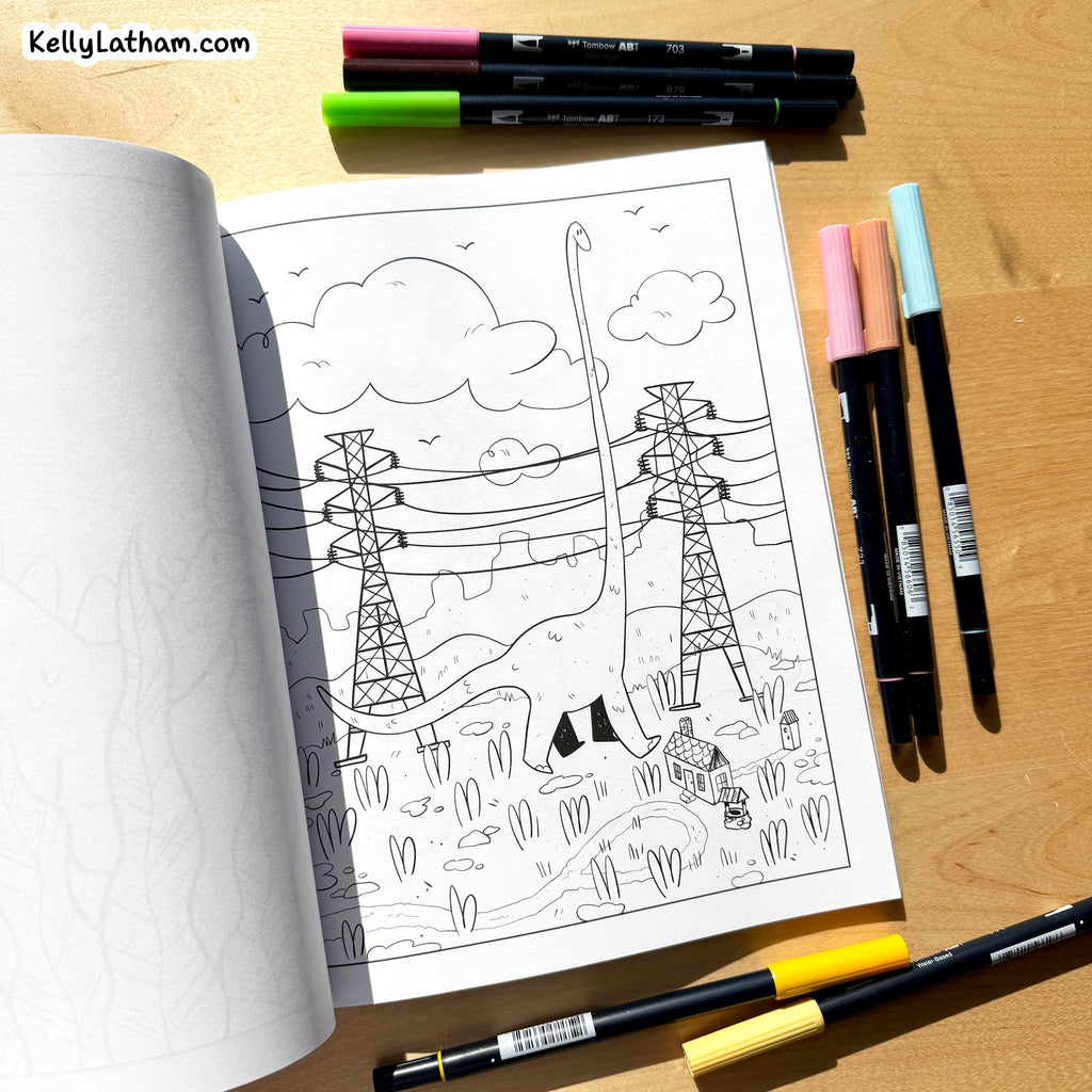 An open coloring book or art journal on a wooden surface, showing a black-and-white line drawing of power lines and a giraffe. Several markers are arranged around it, and the watermark KellyLatham.