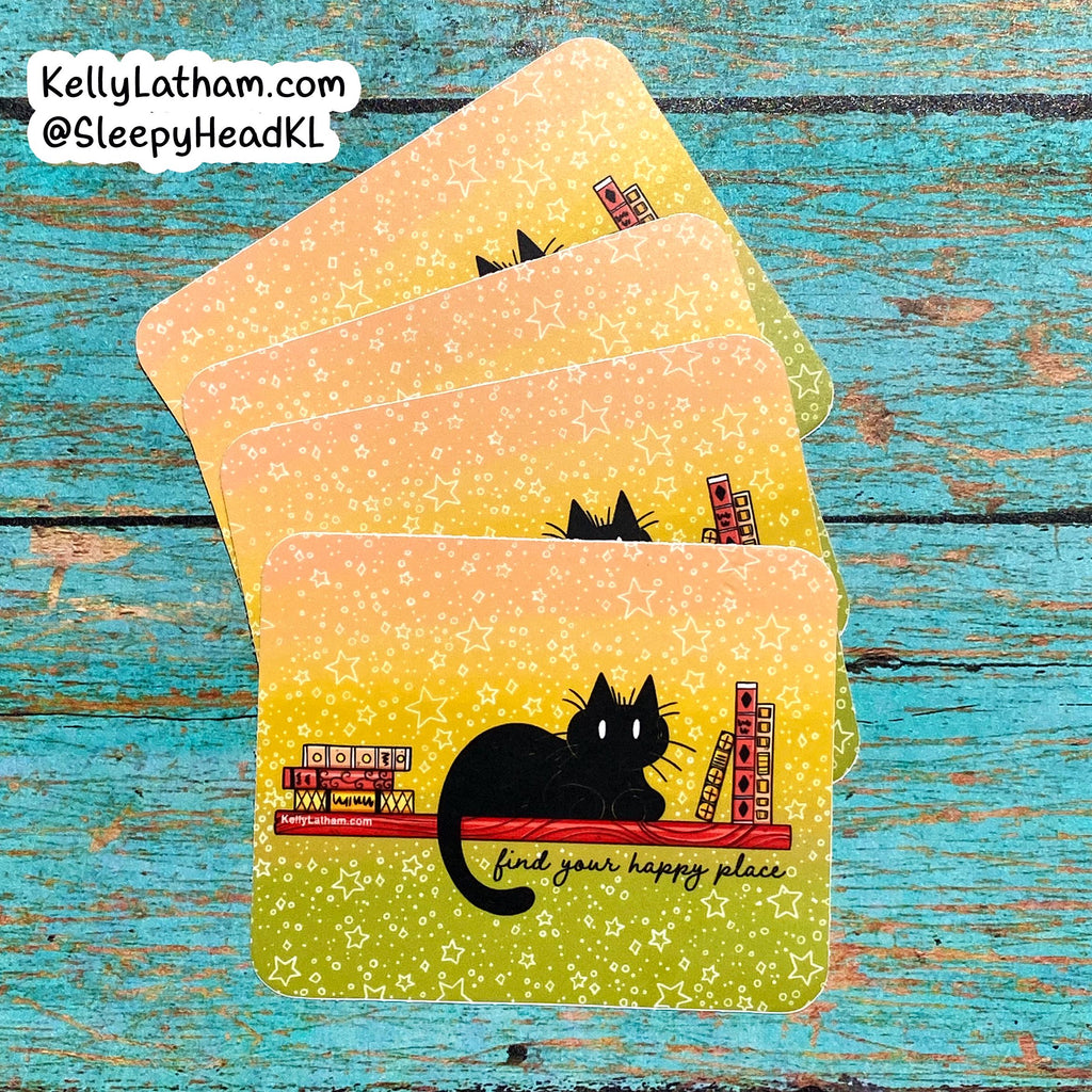 Four rectangular coasters with rounded corners fanned out on a distressed turquoise wood background. The coasters have a yellow-to-green glitter gradient with white speckles, a black cat illustration, and the phrase 'find your happy place.