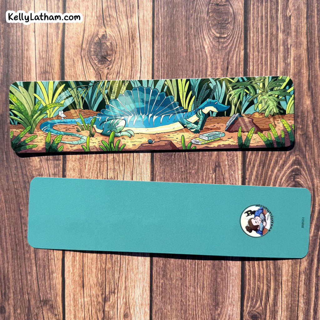 Two yoga mats displayed on a wooden background. The top mat features a colorful illustration of a blue spadeback dinosaur in a jungle, while the bottom mat is solid teal with a small circular cartoon logo near the right edge.