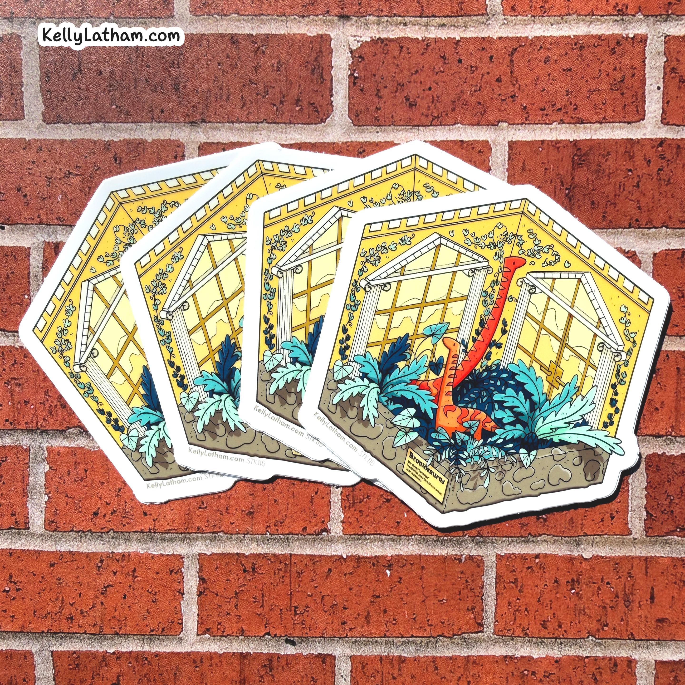 Four hexagonal stickers featuring a colorful illustration of a greenhouse with blue tropical plants and a red dinosaur, displayed on a red brick wall. The brand name 'KellyLatham.