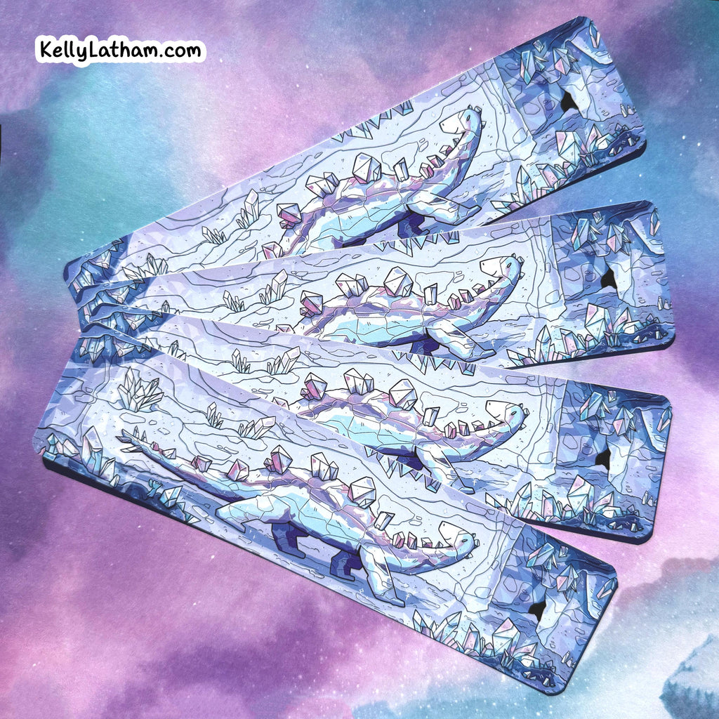 Four rectangular metal keyrings with a detailed fantasy illustration of a blue dragon and crystals, arranged diagonally against a purple and blue galaxy background. The brand name 'KellyLatham.