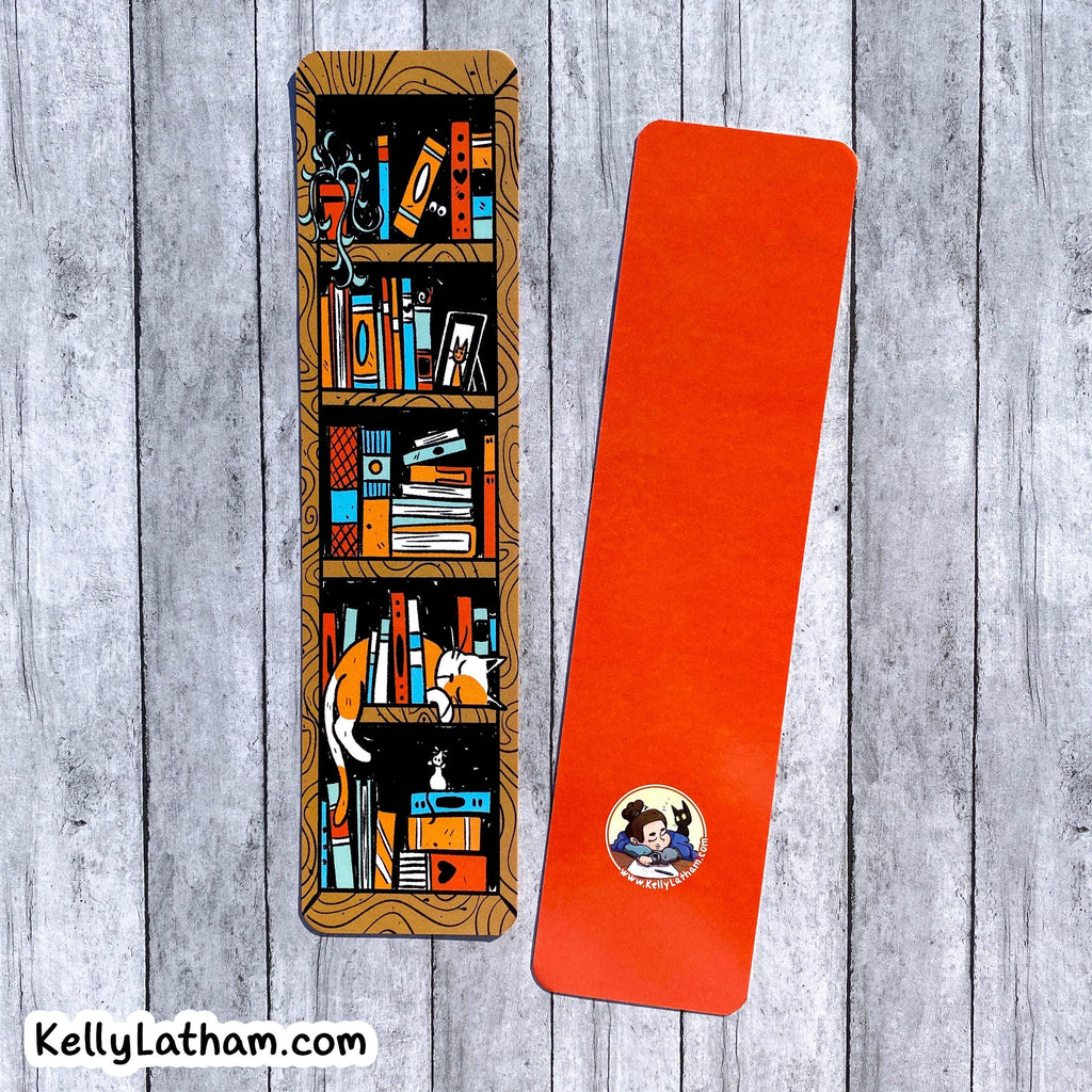 Two bookmarks shown on a gray wood plank background. One mat is illustrated with a bookshelf and books in warm brown, orange, blue, and black tones, while the second mat is solid bright orange with a small circular logo near the bottom.