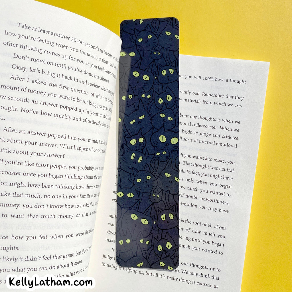 A navy blue bookend with a green and yellow psychedelic pattern, shown resting on an open book against a textured yellow background.