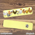 Two yellow bookmarks with cartoon chicken designs on a wooden surface.