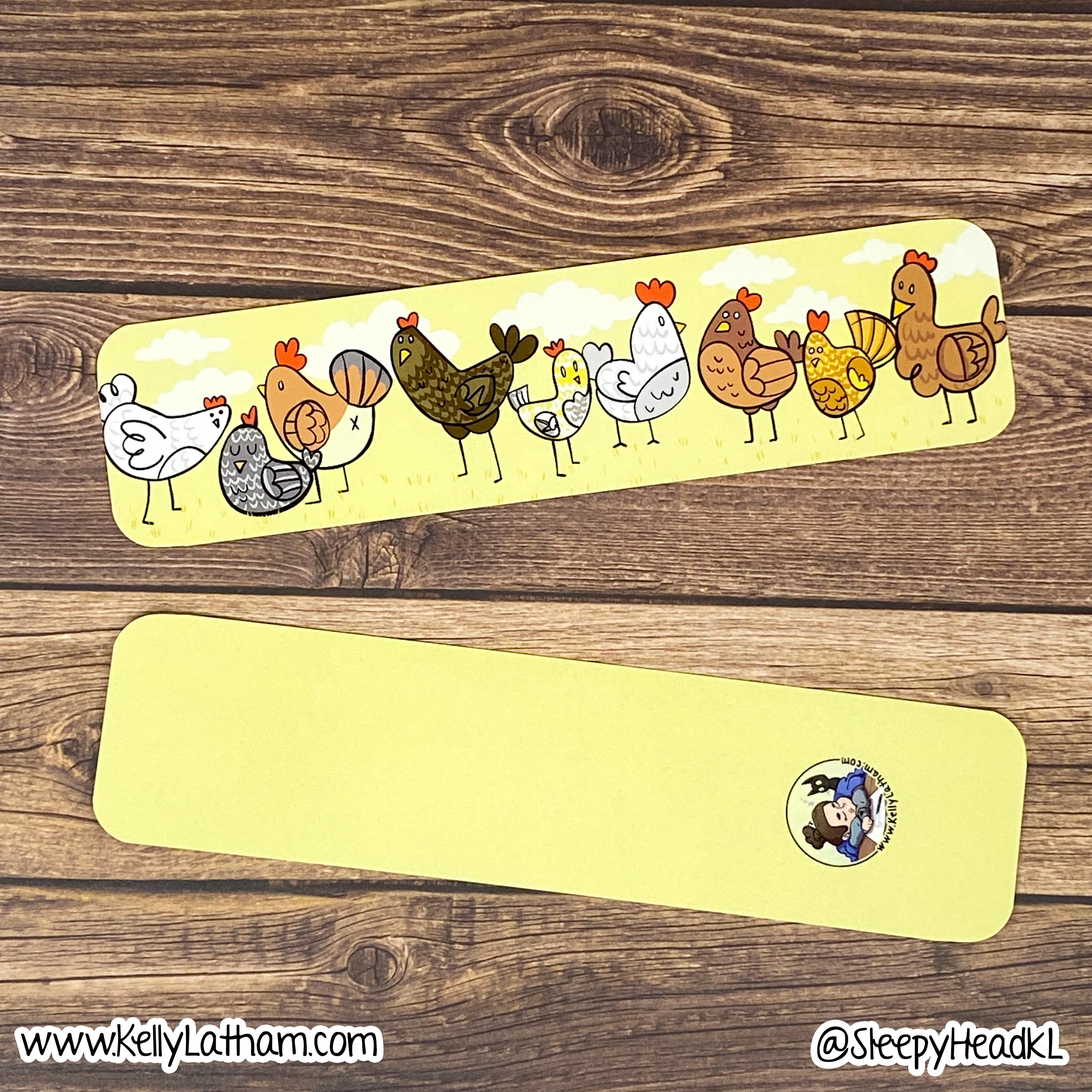 Two yellow bookmarks with cartoon chicken designs on a wooden surface.